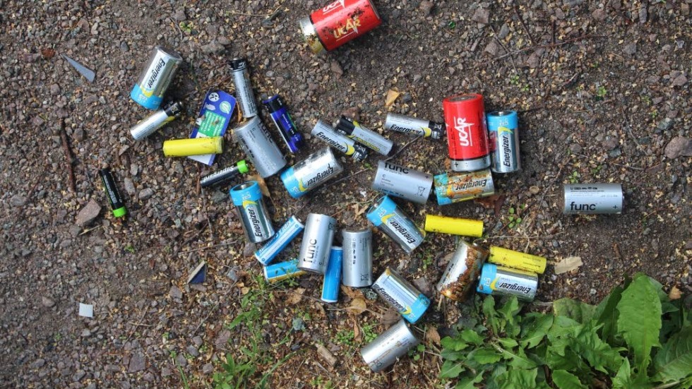 Batterier spridda utanför en återvinningscointaner