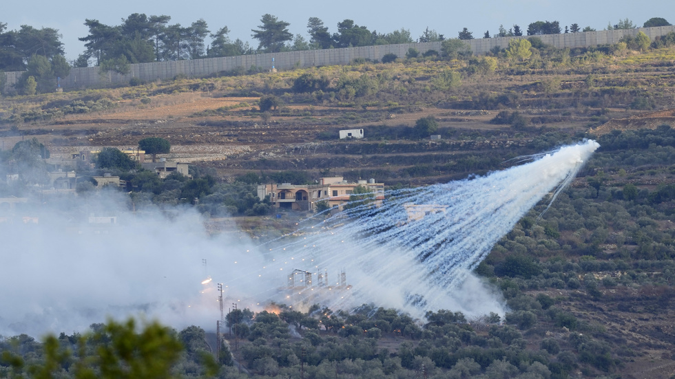 En israelisk artillerigranat exploderar över ett hus i al-Bustan, en libanesisk ort vid gränsen mot Israel, på söndagen.