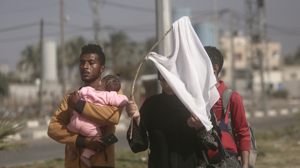 En kvinna håller upp en vit tröja för att undvika israeliska attacker, på väg till södra Gaza med sin familj.