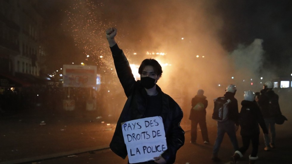 En demonstrant håller upp ett plakat med det syrliga budskapet "Rättsstat för poliser" vid en protest i Paris mot ett lagförslag som skulle inskränka rätten att publicera bilder på poliser i tjänst.