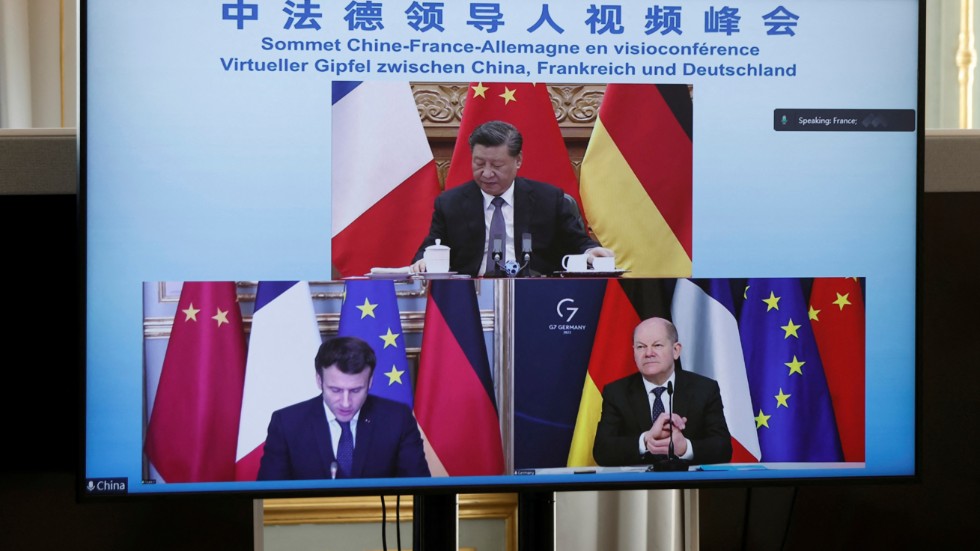 En tv-skärm med Kinas president Xi Jinping, Frankrikes president Emmanuel Macron och Tysklands förbundskansler Olaf Scholz under deras videomöte under tisdagen.