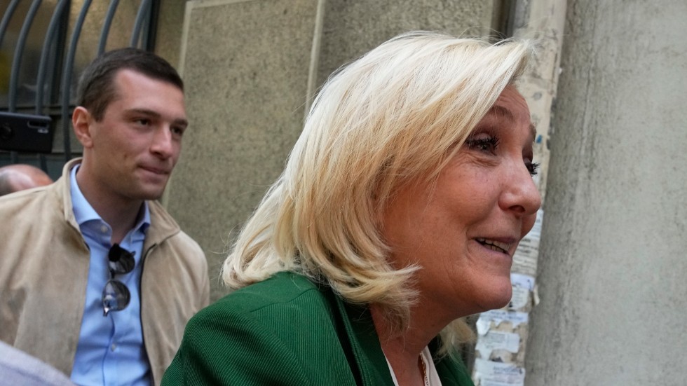 Nationalistledaren Marine Le Pen, följd av kronprinsen tillika tillförordnade partiledaren Jordan Bardella, vid partihögkvarteret i Paris i måndags.