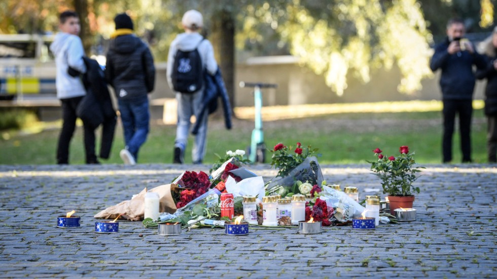 Tända ljus och blommor i närheten av platsen där artisten Einár sköts till döds i Hammarby sjöstad på torsdagskvällen.