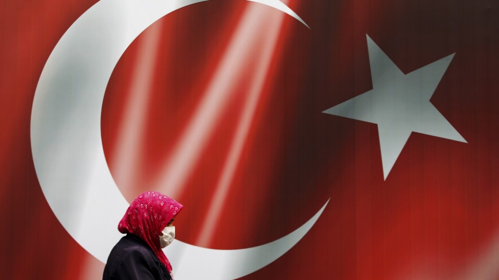 En kvinna går förbi en turkisk flagga i Istanbul. Arkivbild.