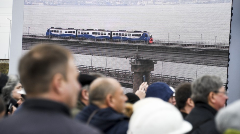 En storbildsskärm visar premiärresan över bron mellan Ryssland och Krimhalvön i december 2019. Vladimir Putin är ombord tåget, som enligt Dossier Center har samma betäckta antenner som presidentens eget bepansrade tåg.