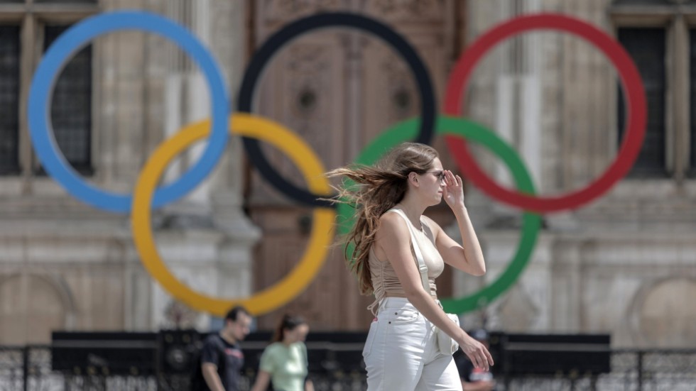 En kvinna passerar de olympiska ringarna i Paris. Arkivbild.