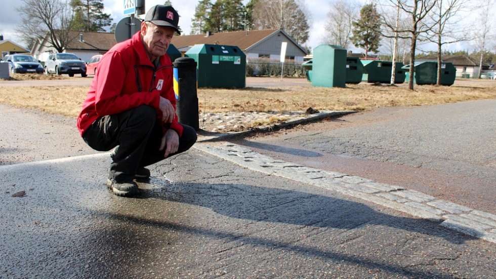 Roland Henricsson visar märken i asfalten efter husvagnar som har slagit i farthindret.