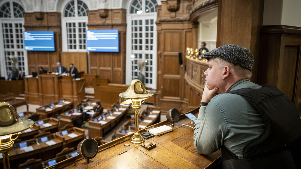 Rasmus Paludan satt på pressläktaren iförd skottsäker väst när folketinget debatterade ett nytt lagförslag om förbud mot koranbränningar i Danmark.