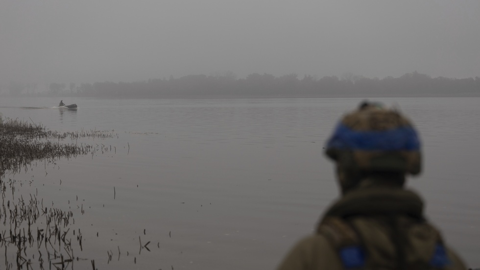 En ukrainsk soldat ser hur en av hans kamrater åker båt på Dnepr i dimman, den 14 oktober. Arkivbild.