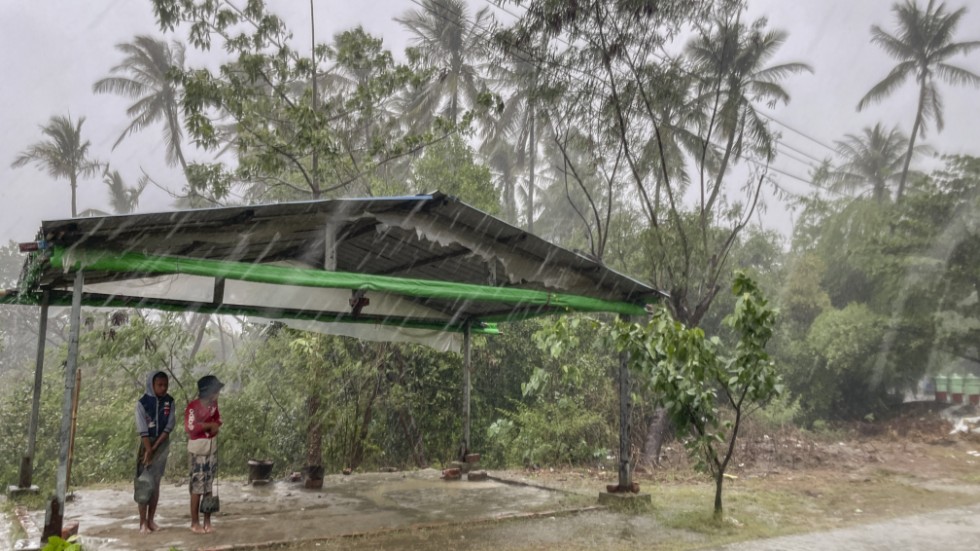 Två barn tar skydd från regnet i Sittwe i delstaten Rakhine.