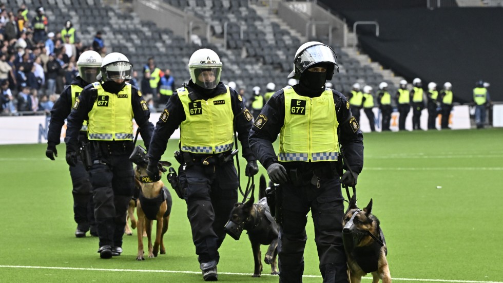 Poliser med hundar och kravallutrustning lämnar planen under söndagens fotbollsmatch i allsvenskan mellan Djurgården och AIK på Tele2 arena i Stockholm.