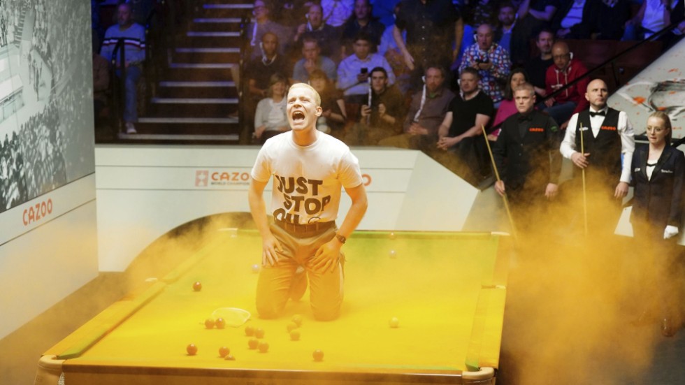 En miljöaktivist på biljardbordet under snooker-VM i Sheffield på måndagen.