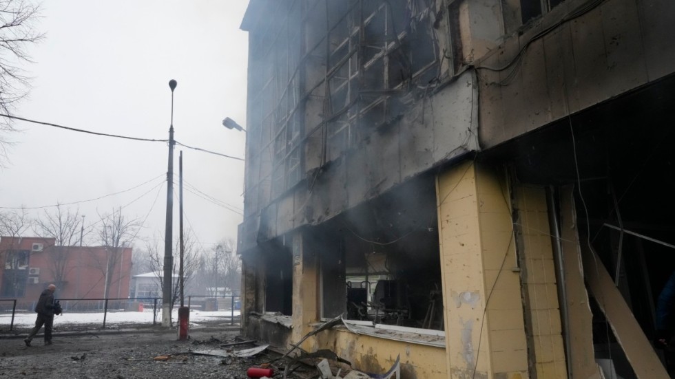 En journalist vid en förstörd byggnad i Kiev. Bilden är tagen den 2 mars 2022.