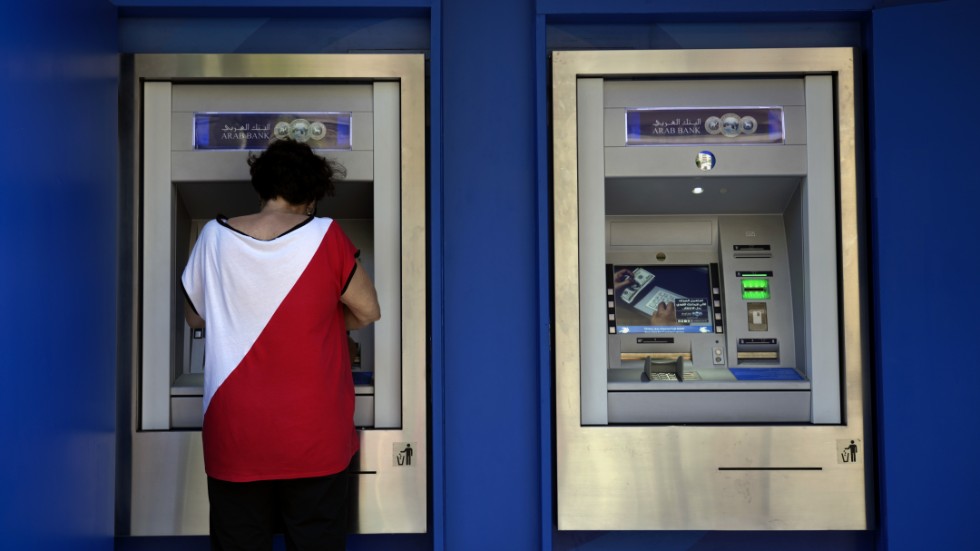 En kvinna tar ut pengar i en bankomat i Beirut tidigare i september.