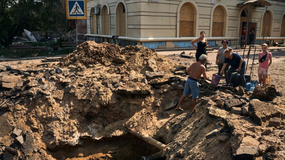 Invånare i Bachmut som Ryssland beskjuter oavbrutet försöker hämta vatten ur en krater efter ett bombanfall. Bild från 31 augusti.
