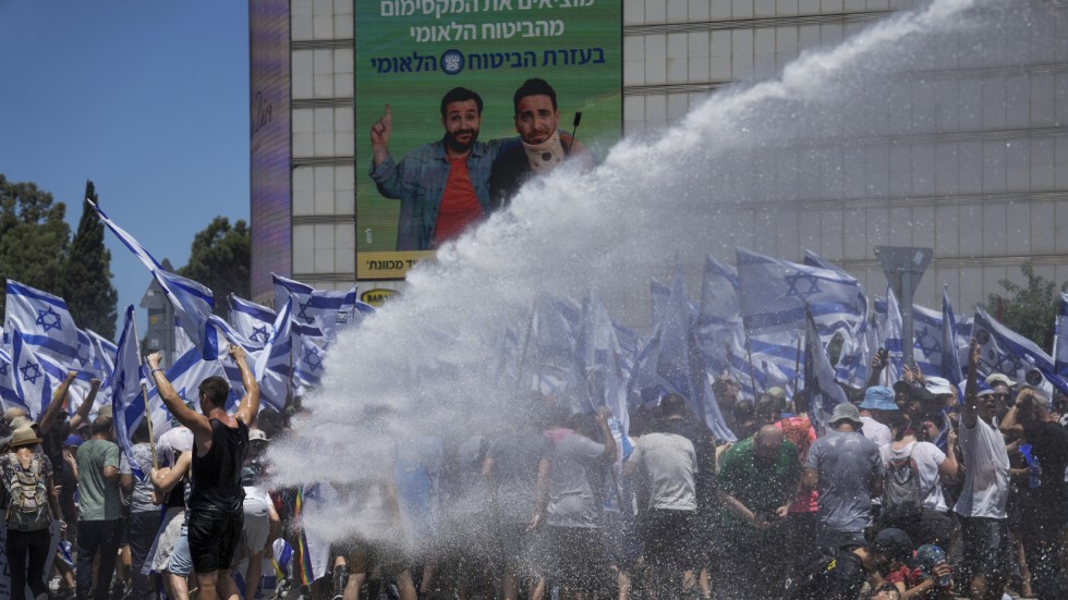 Israelisk polis använder vattenkanoner för att skingra demonstranterna i Tel Aviv.