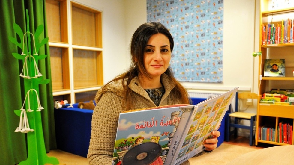 Roya Saydomimi är kulturvärd på biblioteket i Västervik, här visar hon Törnrosa på arabiska. Foto: Åsa Thaberman