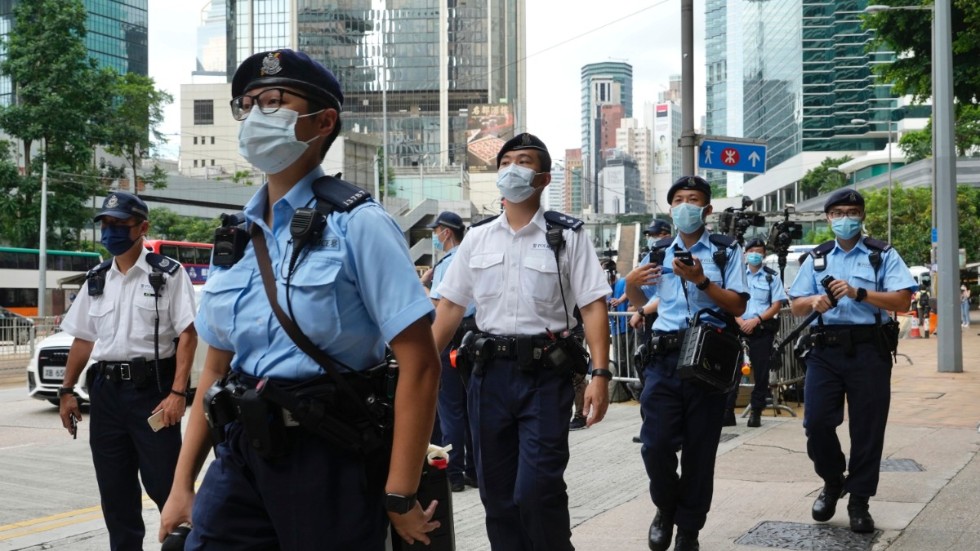Poliser patrullerar i väntan på att aktivisten Tong Ying-kit ska lämna domstolen i Hongkong den 30 juli 2021, efter att ha dömts till nio års fängelse för att ha brutit mot den nationella säkerhetslagen.