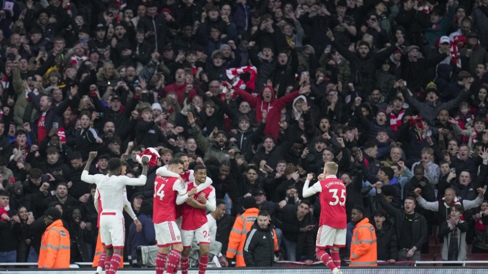 Arsenals spelare och supportrar firar segermålet mot Bournemouth i den 97:e minuten.