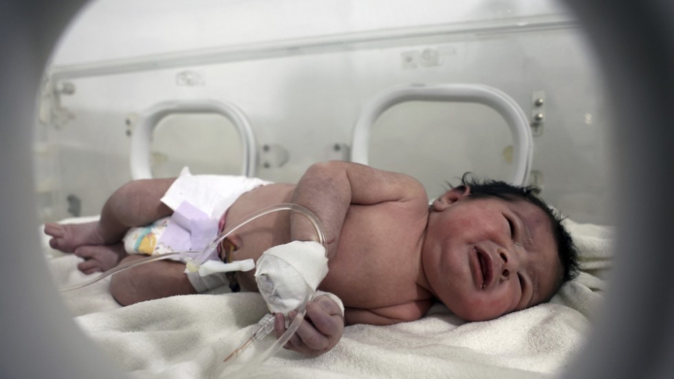 En liten flicka räddades ur rasmassor i norra Syrien på tisdagen. Här ligger spädbarnet på ett sjukhus i Afrin.