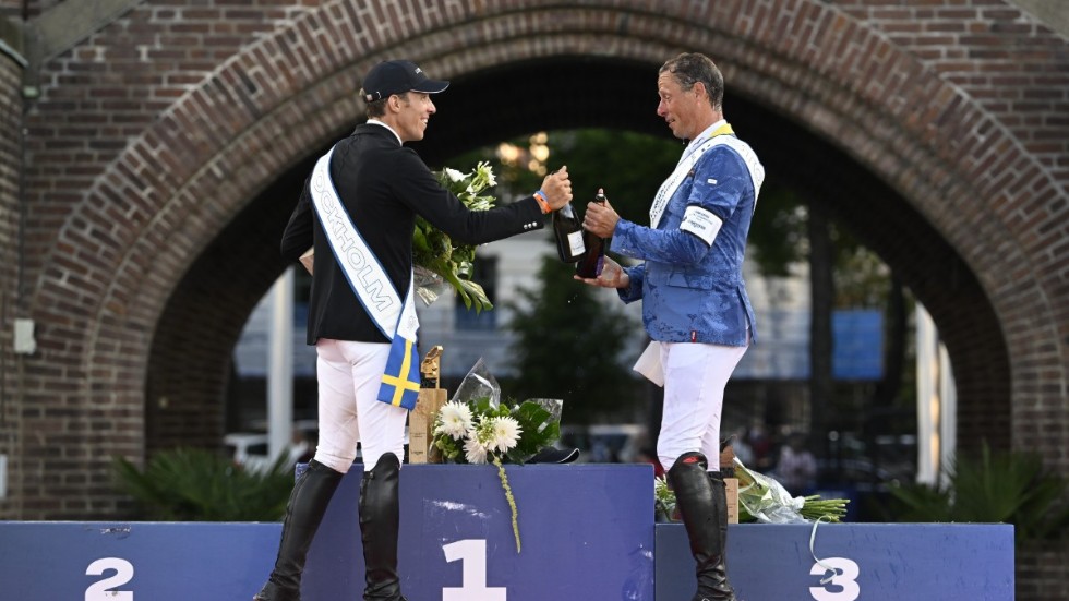 Tvåan Henrik von Eckermann skålar med vinnaren, tysken Christian Ahlmann efter GP-hoppningen i lördags. Den svenske ryttarstjärnan hade stora framgångar på Stockholms stadion.
