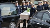 Sorg och beslutsamhet vid begravning av polis