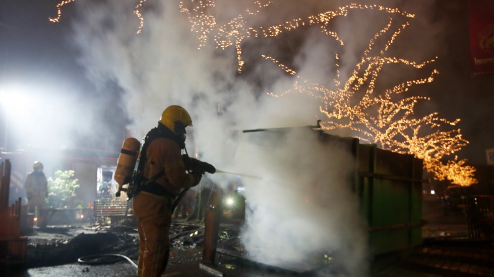 En brandman släcker en eld i Rotterdam under de protester som skakade Nederländerna efter införandet av utegångsförbud med anledning av coronapandemin i januari. Arkivbild.
