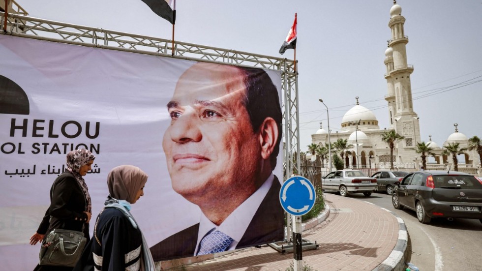 Palestinier går förbi en av de jättebilder av Egyptens president Abd al-Fattah al-Sisi som sattes upp i Gaza City i helgen.