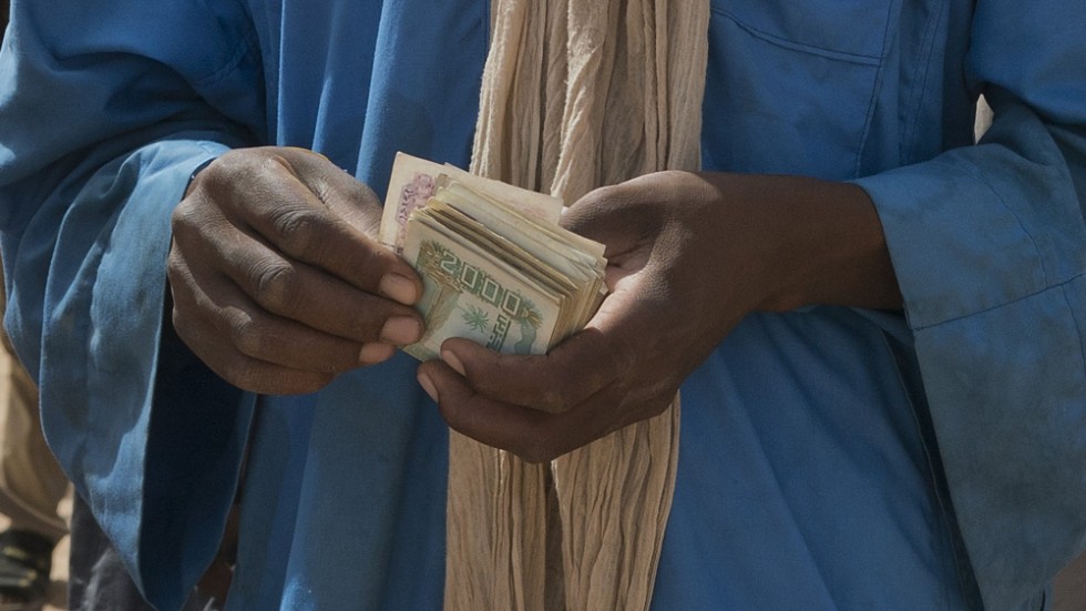 En smugglare i Niger räknar sina pengar, som han fått av migranter som hoppas bli förda in i Algeriet och vidare norrut. Arkivbild från Assamaka.