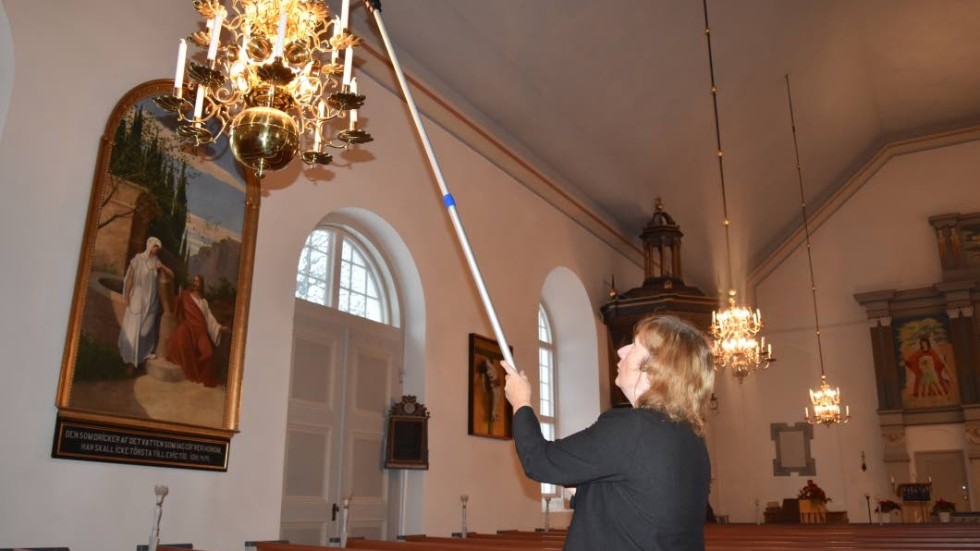 Christina Jäderup, vaktmästare i Hässleby, tänder och släcker många levande ljus i Hässleby kyrka under julen.