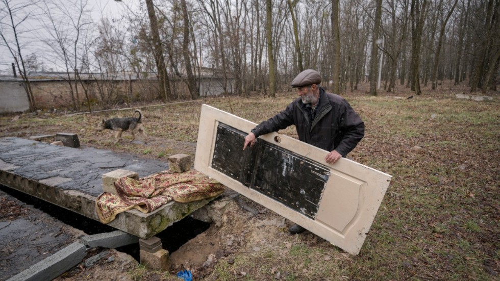 En man i ukrainska Bucha visar på en plats där kroppar av civila har gömts undan. Makabra och fruktansvärda krigsbrott utförda av ryska styrkor avslöjas nu på områden som befriats från ockupation.