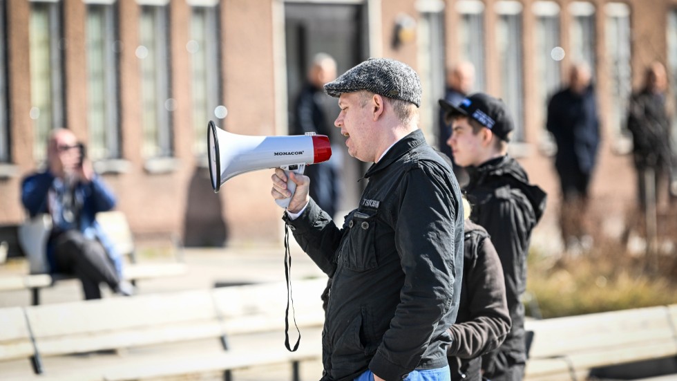 Rasmus Paludan, partiledare för det danska högerextrema partiet Stram kurs, med en megafon i handen, på plats i Stockholmsförorten Rinkeby på långfredagen.