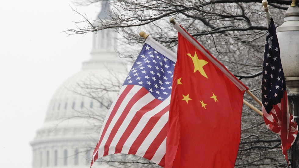 Kineser är mer positivt inställda till det egna landets framtid än vad amerikaner är, visar en ny undersökning. På bilden syns Kapitoliums kupol i Washington bakom en kinesisk flagga och en USA-flagga. Arkivbild.