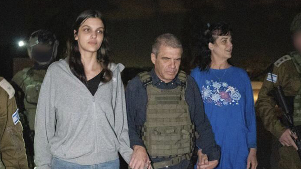 På bilden, som tillhandahållits av Israels regering, syns 17-åriga Natalie Raanan och hennes mamma Judith Raanan när de eskorteras av en israelisk soldat vid sin återkomst till Israel på fredagskvällen.