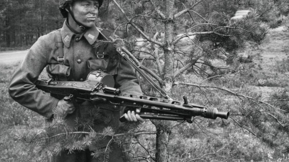 Här ser vi en vicekorpral som förevisar ett nytt vapen då det begav sig i Smålandsskogarna 1957. Han har inget med textens innehåll att göra mer än att ha samma militära grad som ledarskribenten en gång hade. 