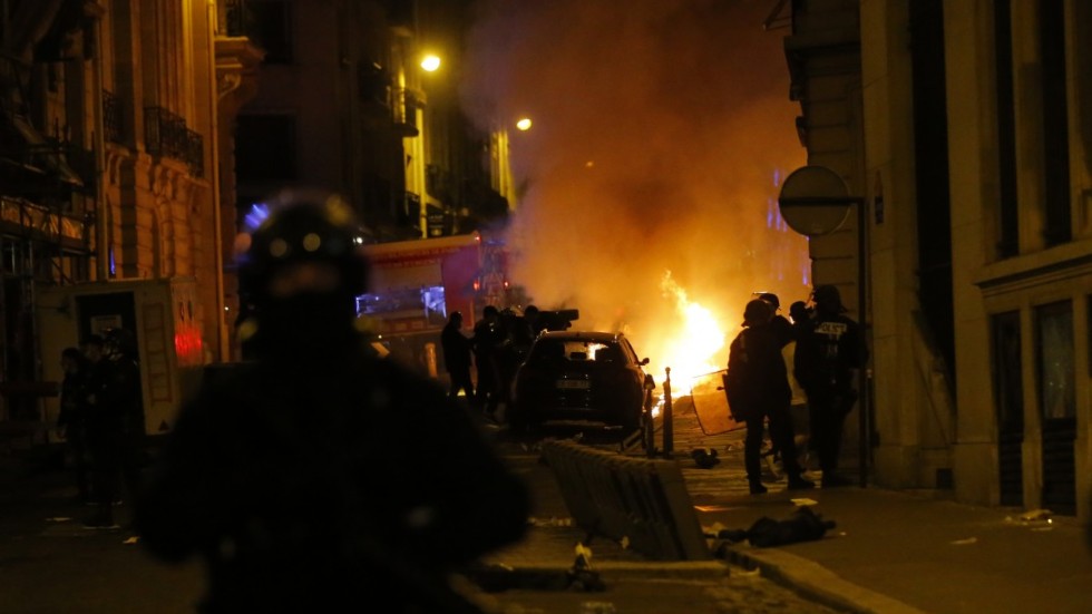Fransk polis ser en bil brinna nära Champs-Élysées efter PSG:s förlust i CL-finalen på söndagen.