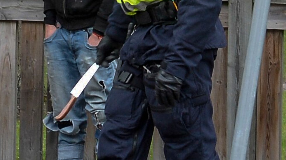 En polis bär bort en kniv som har beslagtagits i samband med en demonstration. Arkivbild.
