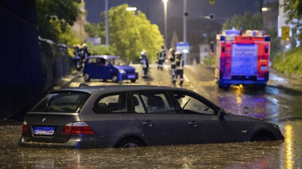 En bil på en översvämmad gata i Stuttgart i Tyskland.