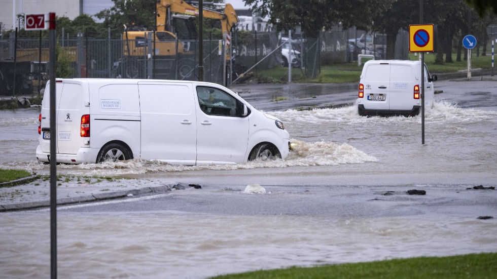 Bilar försöker ta sig genom en översvämmad rondell i Arlöv vid den avstängda, översvämmade Västkustvägen utanför Malmö.