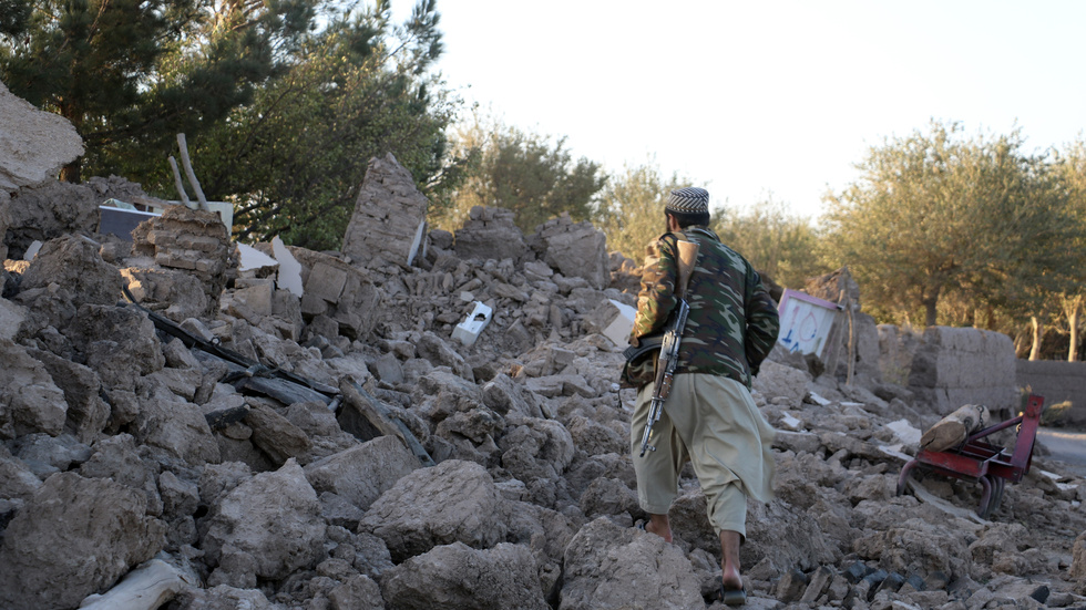 En afghansk man går förbi ett hus som förstörts helt av jordskalvet.