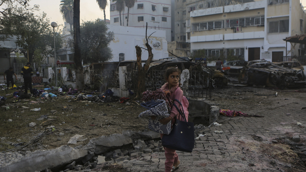 En flicka går förbi det utbrända sjukhuset i Gaza på onsdagen.