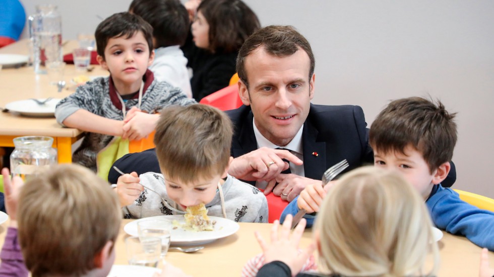 Frankrikes president Emmanuel Macron på besök i en sydfransk skolmatsal 2019. Nu rasar flera av hans ministrar sedan Lyon slutat servera kött till skolbarn under pandemin. Arkivbild.