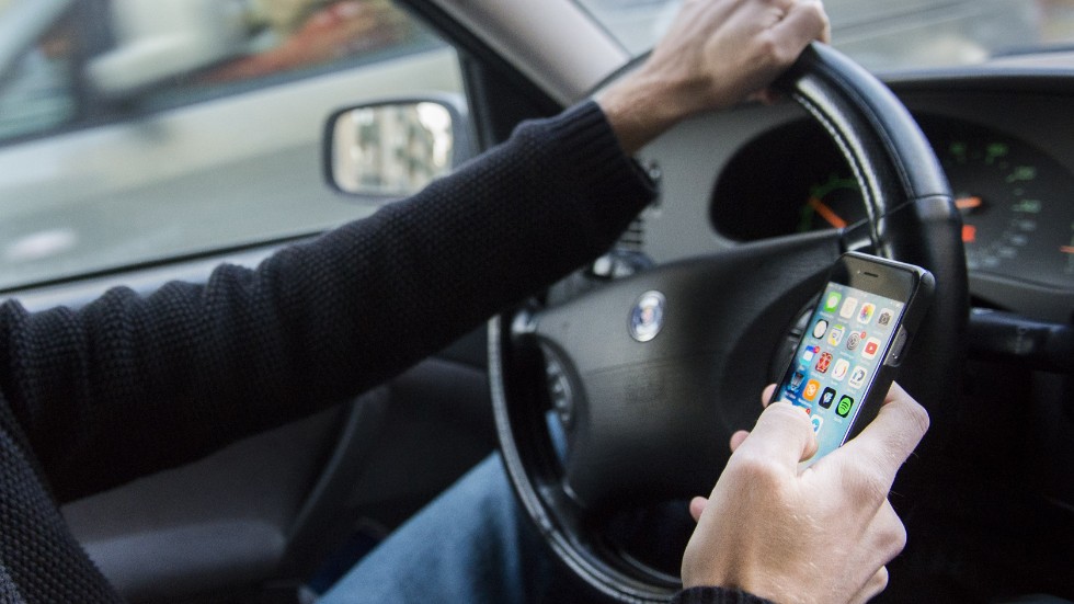 En man döms för att ha hållit mobiltelefonen i handen medan han körde bil. Genrebild.
