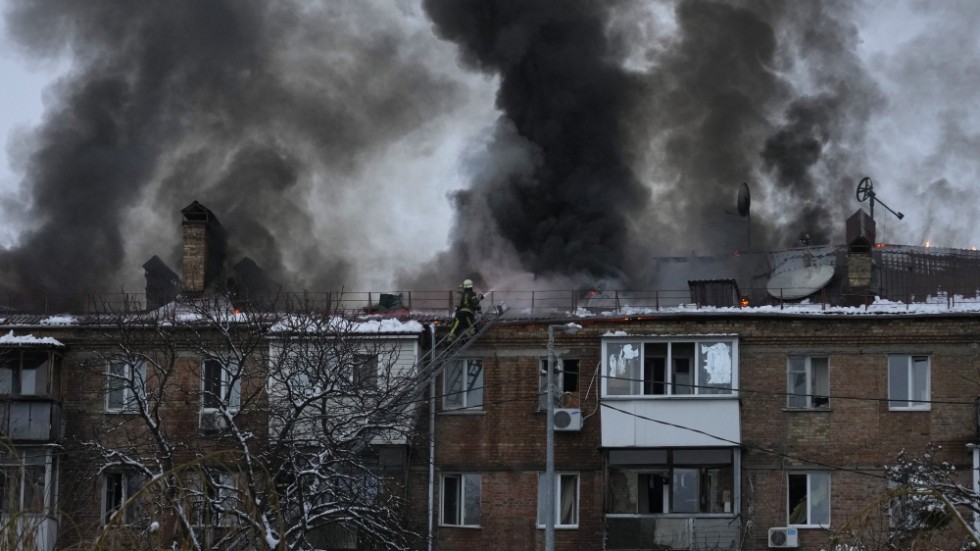 Brandmän kämpar för att släcka elden efter en attack som träffat ett bostadshus utanför Kiev.