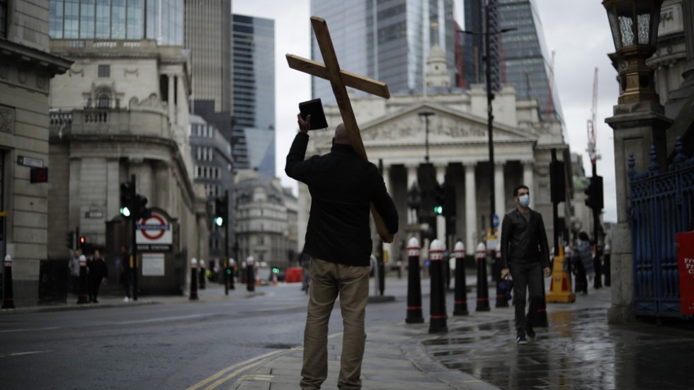 En man med ett stort kors predikar på egen hand i centrala London. Arkivbild från november 2020.