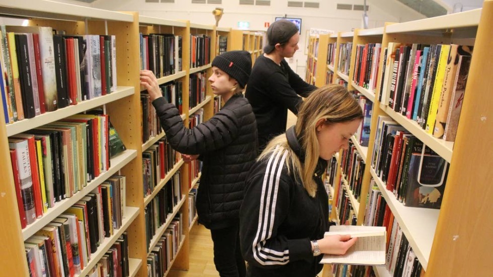 Kompisarna Johan Svensson, Jonn Pouttu och Amelie Stemkowitz trivs på biblioteket och skulle gärna se att det används mer böcker i undervisningen.