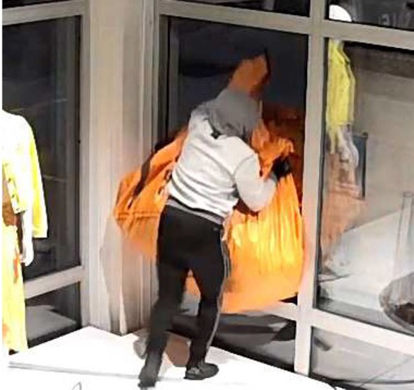 Två män ses lasta ut en orange plastsäck fylld med märkeskläder. Tidigare samma kväll såg en polis säcken och de två dömda i bilen vid en rutinkontroll i Norrköping.