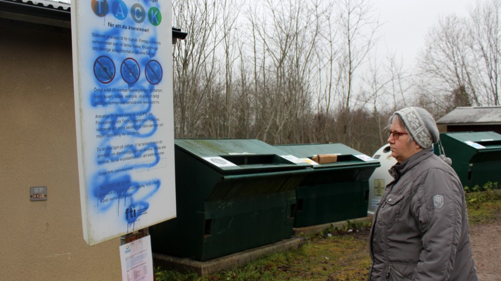 Veronika Axelsson i Ljusfallshammars byaråd vid klottret vid samhällets återvinningsstation.