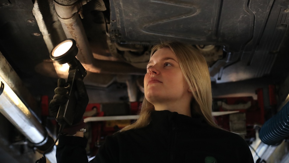 Elina Svensson undersöker en av bilarna på jobbet som besiktningstekniker.