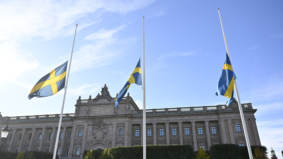 Flaggor på halv stång framför riksdagshuset, som en illustration till vad signaturen "Uppgiven" skriver.